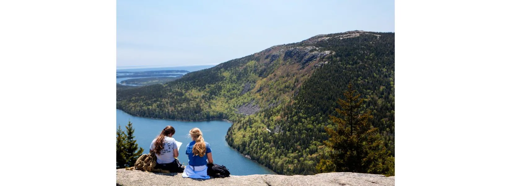 Hikers on trail with scenic Acadia National Park mountain views and forest landscape